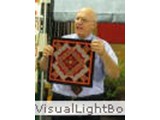 George Siciliano displaying one of his miniatures from his log cabin collection.