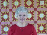 Lucinda Cawley displaying one of her antique quilts.